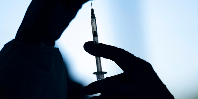 FILE: A medical staff member prepares the Pfizer COVID-19 vaccine at Tudor Ranch in Mecca, Calif.