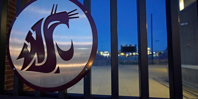 The Washington State Cougar logo is displayed on a gate at Martin Stadium, Monday, Oct. 18, 2021, in Pullman, Wash. Head football coach Nick Rolovich and four of his assistants were fired on Monday for refusing a state mandate that all employees get vaccinated against COVID-19, making him the first major college coach to lose his job over vaccination status.