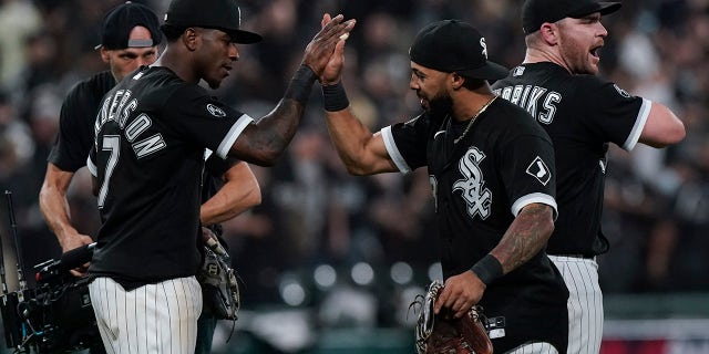 The Chicago White Sox's Tim Anderson (7) and Leury Garcia, center, celebrate with Liam Hendriks, right, after beating the Houston Astros 12-6 in Game 3 of the American League Division Series Sunday, Oct. 10, 2021, in Chicago.