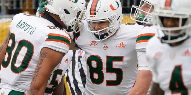 Miami tight end Will Mallory (85) celebrates with Elijah Arroyo (80) and others after making a touchdown catch against Pittsburgh during the first half of an NCAA college football game, Saturday, Oct. 30, 2021, in Pittsburgh.