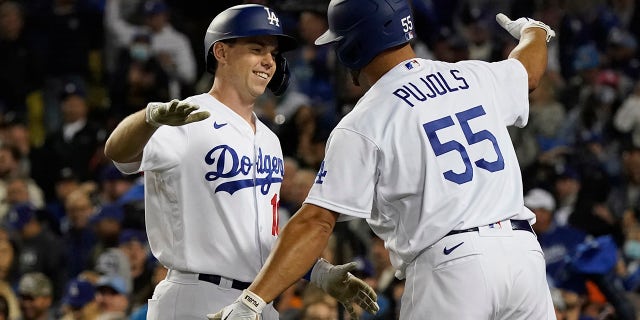 The Los Angeles Dodgers' Will Smith, izquierda, is greeted by Albert Pujols (55) after Smith hit a two-run home run to score Corey Seager during the eighth inning of Game 4 of the National League Division Series against the San Francisco Giants, martes, oct. 12, 2021, En los angeles. The Dodgers won 7-2.