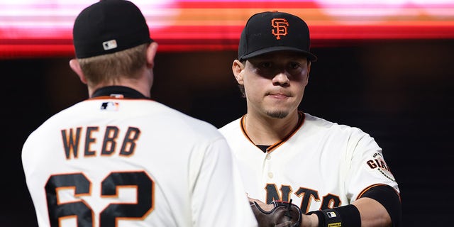 Wilmer Flores and Logan Webb (62) of the San Francisco Giants celebrate against the Los Angeles Dodgers during the fifth inning of Game 1 of the National League Division Series at Oracle Park on Oct. 8, 2021, in San Francisco, California.