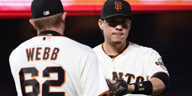 Wilmer Flores and Logan Webb (62) of the San Francisco Giants celebrate against the Los Angeles Dodgers during the fifth inning of Game 1 of the National League Division Series at Oracle Park on Oct. 8, 2021, in San Francisco, California.