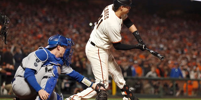 San Francisco Giants' Wilmer Flores, right, is called out swinging in front of Los Angeles Dodgers catcher Will Smith for the final out of the ninth inning of Game 5 of a baseball National League Division Series Thursday, Oct. 14, 2021, in San Francisco.