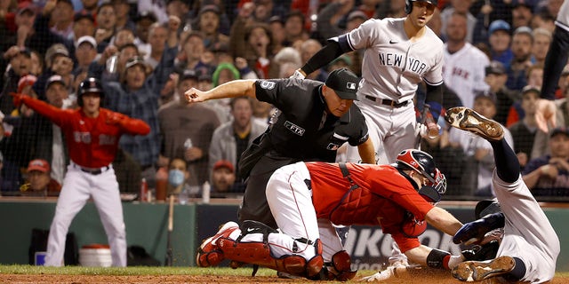 Aaron Judge of the New York Yankees is tagged by Kevin Plawecki of the Boston Red Sox during the sixth inning of the American League Wild Card game at Fenway Park on October 5, 2021 in Boston, Massachusetts.