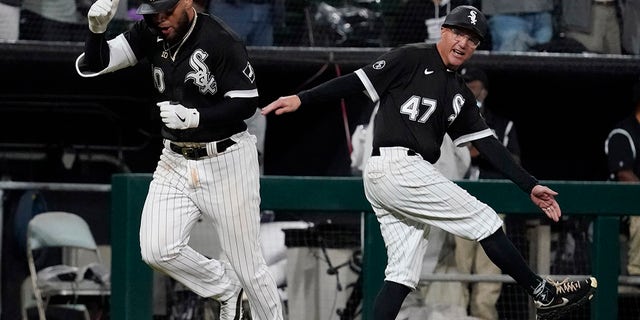 Chicago White Sox Yoán Moncada, left, celebrates with third baseman Joe McEwing after hitting a two-run homer in the eighth inning of a baseball game against the Detroit Tigers in Chicago on Saturday October 2, 2021.