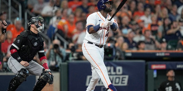 Houston Astros designated hitter Yordan Alvarez watches the ball as he hits a solo home run off Chicago White Sox relief pitcher Reynaldo Lopez during the fifth inning in Game 1 of a baseball American League Division Series Thursday, Oct. 7, 2021, in Houston. White Sox catcher Yasmani Grandal watches the ball as well.
