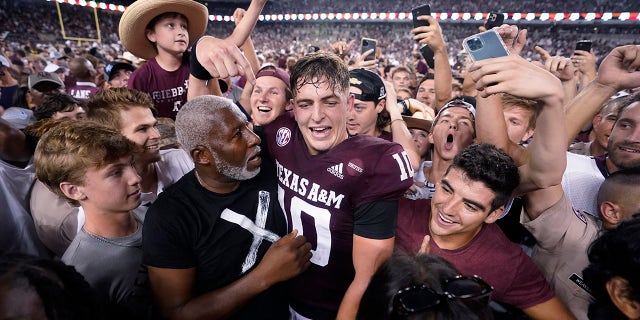 Le quart-arrière du Texas A&M Zach Calzada (10) est entouré de fans après la victoire de l'équipe contre l'Alabama lors d'un match de football universitaire de la NCAA le samedi 9 octobre 2021 à College Station, Texas.