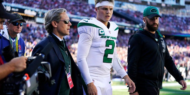 New York Jets quarterback Zach Wilson (2) is escorted to the locker room after an apparent injury during the first half of an NFL football game against the New England Patriots, Sunday, Oct. 24, 2021, in Foxborough, Mass.