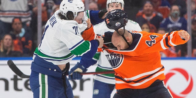 Vancouver Canucks Zack MacEwen (71) and Edmonton Oilers Zack Kassian (44) face off in the third period of an NHL pre-season game on Thursday, October 7, 2021 in Edmonton, Alta.