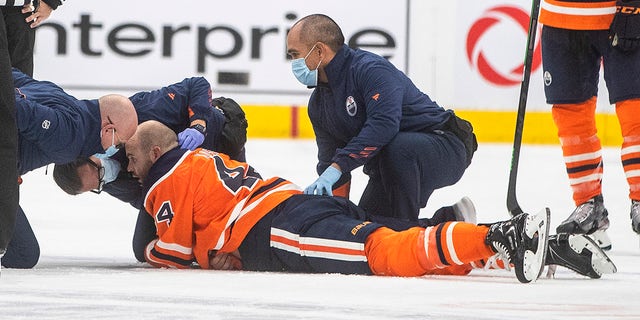 Edmonton Oilers Zack Kassian (44) is treated by medics after a fight with Vancouver Canucks Zack MacEwen in the third period of an NHL preseason game on Thursday October 7, 2021 in Edmonton, Alta. .