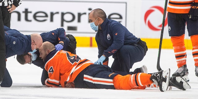 Edmonton Oilers' Zack Kassian (44) is tended to by medical staff after a fight with Vancouver Canucks' Zack MacEwen during the third period of an NHL hockey preseason game Thursday, Oct. 7, 2021, in Edmonton, Alberta.