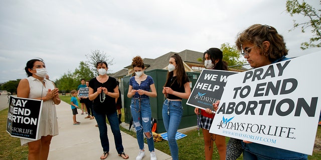 Anti-abortion demonstrators pray and protest outside of a Whole Women's Health of North Texas, Friday, Oct. 1, 2021, in McKinney, Texas. Observers of the Supreme Court thought Monday that it may rule on a procedural issue in the case, but it did not. (AP Photo/Brandon Wade)