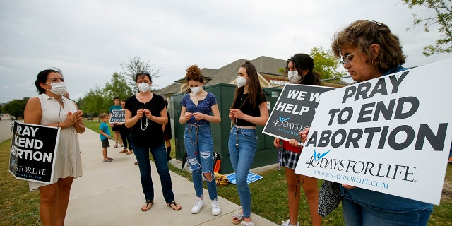 Anti-abortion demonstrators pray and protest outside of a Whole Women's Health of North Texas, Friday, Oct. 1, 2021, in McKinney, Texas. Observers of the Supreme Court thought Monday that it may rule on a procedural issue in the case, but it did not. (AP Photo/Brandon Wade)