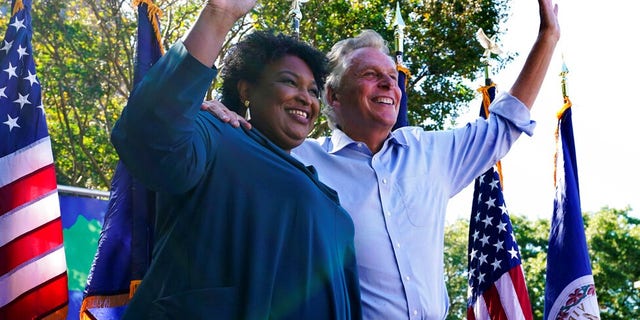Political activist Stacey Abrams, 剩下, waves to the crowd with Democratic gubernatorial candidate, 前弗吉尼亚州州长. 特里·麦考利夫, 对, during a rally in Norfolk, 维吉尼亚州. 