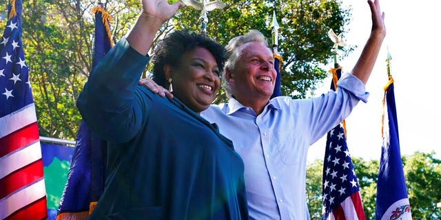 Political activist Stacey Abrams, left, waves to the crowd with Democratic gubernatorial candidate, former Virginia Gov. Terry McAuliffe, right, during a rally in Norfolk, Virginia.