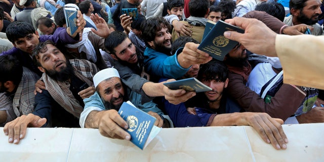 FILE PHOTO: Afghan men wait to collect tokens needed to apply for the Pakistan visa, in Jalalabad, Afghanistan October 21, 2020. REUTERS/Stringer/File Photo