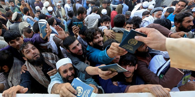 FILE PHOTO: Afghan men wait to collect tokens needed to apply for the Pakistan visa, in Jalalabad, Afghanistan October 21, 2020. REUTERS/Stringer/File Photo