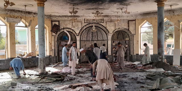 People view the damage inside of a mosque following a bombing in Kunduz, province northern Afghanistan, Friday, Oct. 8, 2021. (AP Photo/Abdullah Sahil)