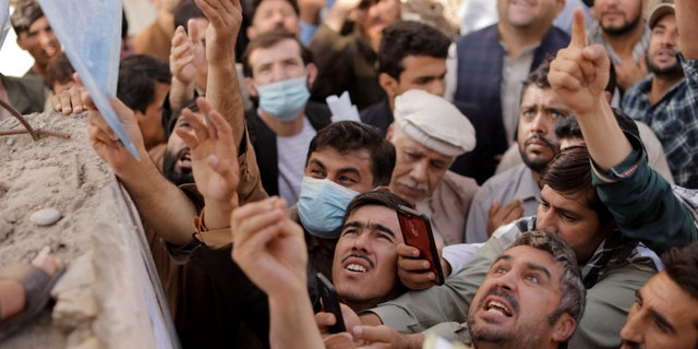 Afghans gather outside the passport office after Taliban officials announced they will start issuing passports to its citizens again, following months of delays that hampered attempts by those trying to flee the country after the Taliban seized control, in Kabul, Afghanistan Oct. 6, 2021. (REUTERS/Jorge Silva)