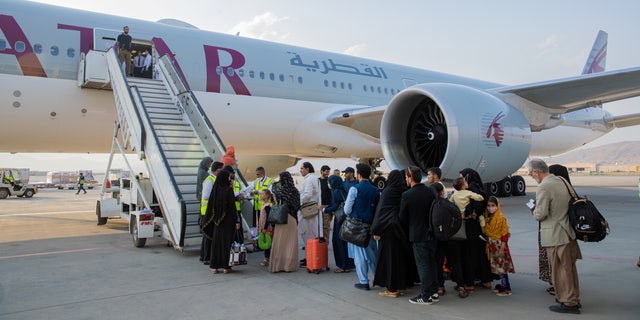 Afghan passengers are pictured in-front of a Qatar Airways airplane at Kabul International Airport, in Kabul, Afghanistan September 19, 2021. Qatar's Ministry of Foreign Affairs/Handout via REUTERS ATTENTION EDITORS - THIS IMAGE HAS BEEN SUPPLIED BY A THIRD PARTY. NO RESALES. NO ARCHIVES.