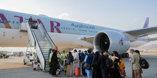 Afghan passengers are pictured in-front of a Qatar Airways airplane at Kabul International Airport, in Kabul, Afghanistan September 19, 2021. Qatar's Ministry of Foreign Affairs/Handout via REUTERS ATTENTION EDITORS - THIS IMAGE HAS BEEN SUPPLIED BY A THIRD PARTY. NO RESALES. NO ARCHIVES.
