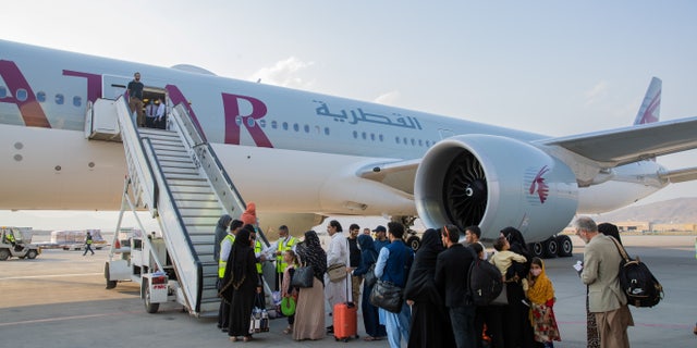 Afghan passengers are pictured in-front of a Qatar Airways airplane at Kabul International Airport, in Kabul, Afghanistan September 19, 2021. Qatar's Ministry of Foreign Affairs/Handout via REUTERS ATTENTION EDITORS - THIS IMAGE HAS BEEN SUPPLIED BY A THIRD PARTY. NO RESALES. NO ARCHIVES.