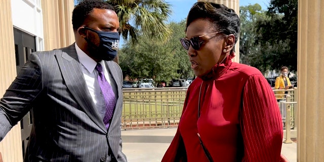 Ahmaud Arbery's mother, Wanda Cooper-Jones, heads into the Glynn County Courthouse in Brunswick, Georgia, while her attorney attorney Lee Meritt on Monday.