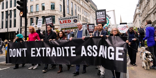 Julian Assange's partner Stella Moris, fourth left, and Wikileaks editor-in-chief Kristin Hrafnsson, fifth left, with supporters of WikiLeaks founder Julian Assange hold placards and take part in a march in London on Oct. 23, 2021, ahead of next week's extradition case appeal.