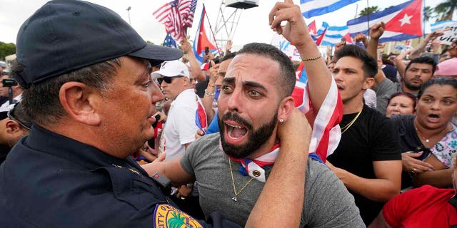 Ce mercredi 14 juillet 2021, photo d'archives, le chef de la police de Miami, Art Acevedo, à gauche, étreint un manifestant dans les environs de Little Havana, Miami.