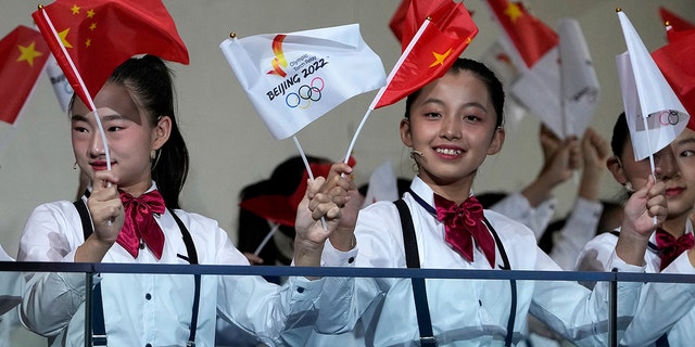 Children wave national flags and Beijing 2022 Winter Olympic Games flags during a welcome ceremony for the Frame of Olympic Winter Games Beijing 2022.