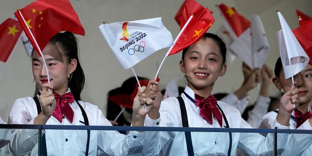 Children wave national flags and Beijing 2022 Winter Olympic Games flags during a welcome ceremony for the Frame of Olympic Winter Games Beijing 2022.