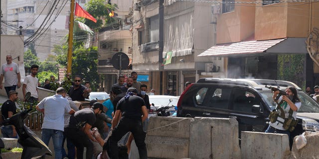 Supporters of a Shiite group allied with Hezbollah help an injured comrade during armed clashes that erupted during a protest in the southern Beirut suburb of Dahiyeh, Lebanon, on Thursday.