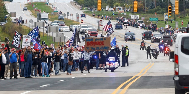Anti-Biden protesters take to the streets as they mock the President's motorcade after a visit to the International Union of Operating Engineers Local 324 Training Center in Howell, Michigan on October 5, 2021.