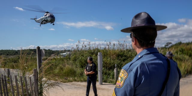 A Delaware State Trooper watches as Marine One carrying U.S. President Joe Biden takes off from Gordons Pond in Rehoboth Beach, Delaware, U.S., September 20, 2021. REUTERS/Ken Cedeno