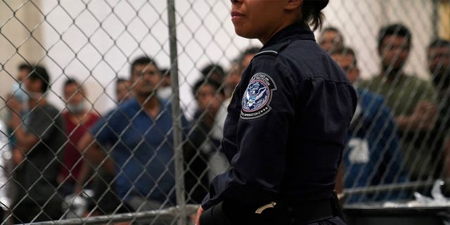 A U.S. Customs and Border Protection agent monitors single-adult male detainees at Border Patrol station in McAllen, Texas.