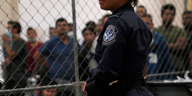 A U.S. Customs and Border Protection agent monitors single-adult male detainees at Border Patrol station in McAllen, Texas.