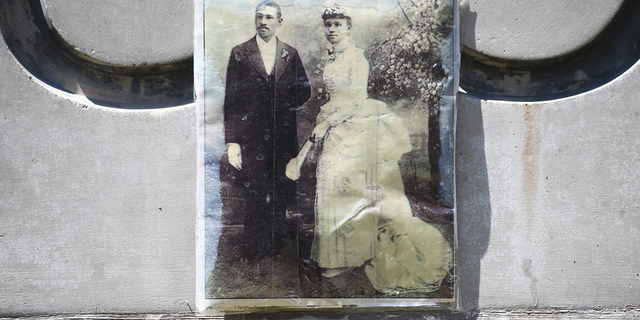 MANHATTAN BEACH, CALIFORNIA - APRIL 19: A photo of Charles and Willa Bruce is attached to a plaque marking Bruce's Beach on April 19, 2021 in Manhattan Beach, California. The beachfront property was once a seaside resort owned by Charles and Willa Bruce, a Black couple, which catered to African Americans. Amid the Jim Crow era, the city claimed the property in 1924 through eminent domain while vastly underpaying the couple for the land. Los Angeles County is making plans to return the prime beachfront property, which may be worth $75 million, to Bruce family descendants. (Photo by Mario Tama/Getty Images)