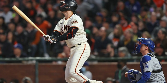 San Francisco Giants' Buster Posey, left, watches his two-run home run past Los Angeles Dodgers wide receiver Will Smith in the first inning of Game 1 of a National League Baseball Division Series on Friday October 8, 2021, in San Francisco.  (AP Photo / John Hefti)