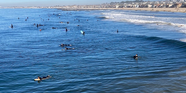 Surfers head out in Newport Beach, California, on Wednesday.