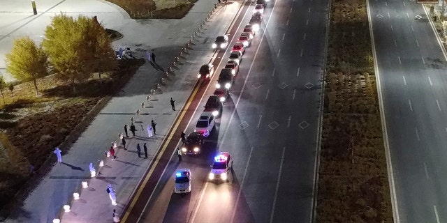 In this aerial photo released by Xinhua News Agency, stranded self-driving tourists prepare to leave Alxa League's Ejina Banner for two-week quarantine hotels on Thursday in the Inner Mongolia Autonomous Region of the northern China.