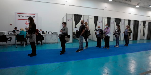 People wait in line to receive a dose of a COVID-19 vaccine at Belgrade Fair makeshift vaccination center in Belgrade, Serbia, Saturday, Oct. 2, 2021. Russians are flocking to Serbia to receive Western-approved COVID-19 shots. Although Russia has its own vaccine known as Sputnik V, the shot has not been approved by international health authorities. (AP Photo/Darko Vojinovic)