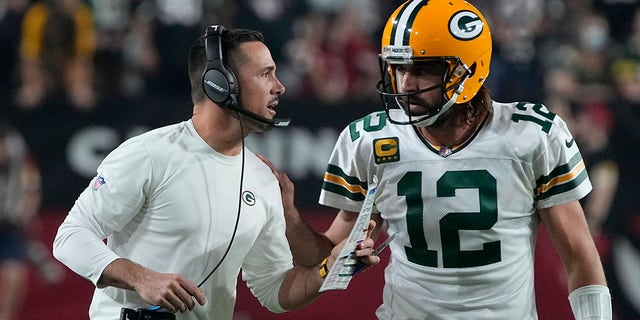 Green Bay Packers head coach Matt LaFleur talks with quarterback Aaron Rodgers during the first half of an NFL football game against the Arizona Cardinals, Thursday, Oct. 28, 2021, in Glendale, Arizona.