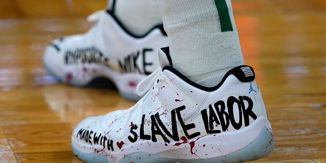 Boston Celtics center Enes Kanter displays a message on his shoes during the first half of an NBA basketball game against the Washington Wizards, Wednesday, Oct. 27, 2021, in Boston. 