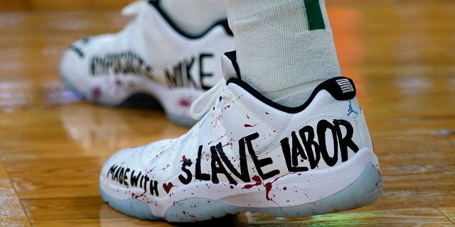 Enes Kanter of the Boston Celtics Center displays a message on his shoes during the first half of the NBA basketball game against the Washington Wizards in Boston on Wednesday, Oct. 27, 2021. 