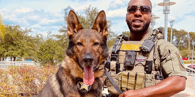 Dawson, pictured above with his K-9 partner Baro, was hailed by the sheriff's office as a hero for running into the home and rescuing the 3-year-old boy.