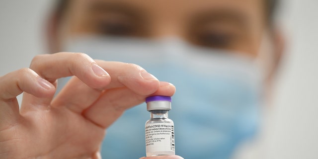 A member of staff poses with a phial of Pfizer-BioNTech COVID-19 vaccine at a vaccination health center on the first day of the largest immunization program in the U.K.'s history on Dec, 8, 2020 in Cardiff, United Kingdom. 