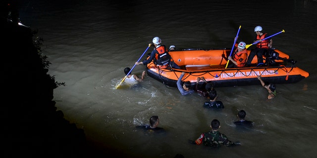 Rescuers search for victims of drowning in a river in Ciamis, West Java, Indonesia, Friday, Oct. 15, 2021. 