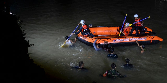 Rescuers search for victims of drowning in a river in Ciamis, West Java, Indonesia, Friday, Oct. 15, 2021. 