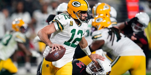 Green Bay Packers quarterback Aaron Rodgers (12) pushes down Arizona Cardinals linebacker Markus Golden (44) during the first half of an NFL football game, Thursday, Oct. 28, 2021, in Glendale, Ariz. 